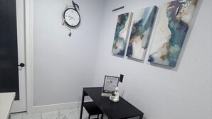 A small, modern room with a white door, a black-framed table with two chairs, and three abstract paintings on the wall. - Comfort, location and a fair price, ALL IN ONE PLACE (Las Vegas)