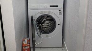 A compact, wall-mounted washer and dryer unit in a small laundry room with a tiled floor. - Comfort, location and a fair price, ALL IN ONE PLACE (Las Vegas)