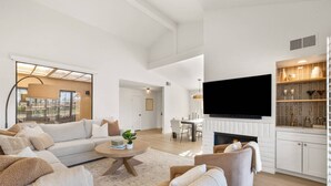 Amplia sala de estar con un sofá grande, una mesa de centro y una chimenea.