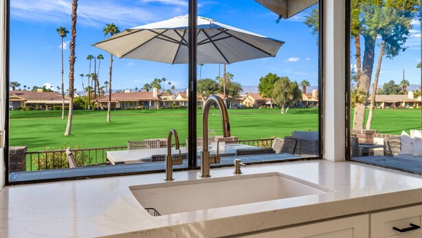 Cocina moderna con un amplio ventanal con vistas a un campo de golf.