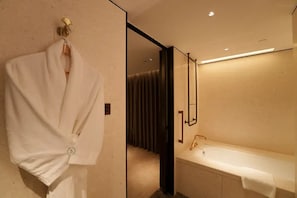 A modern bathroom with a bathtub, a towel rack with a white towel, and a mirror. - CANTON HOTEL BEIJING (Beijing)