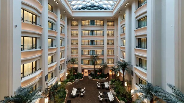 A multi-level atrium with a glass ceiling, multiple balconies, and a central courtyard with seating areas. - CANTON HOTEL BEIJING (Beijing)