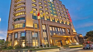 A modern hotel with multiple floors, a prominent entrance, and flags. - CANTON HOTEL BEIJING (Beijing)
