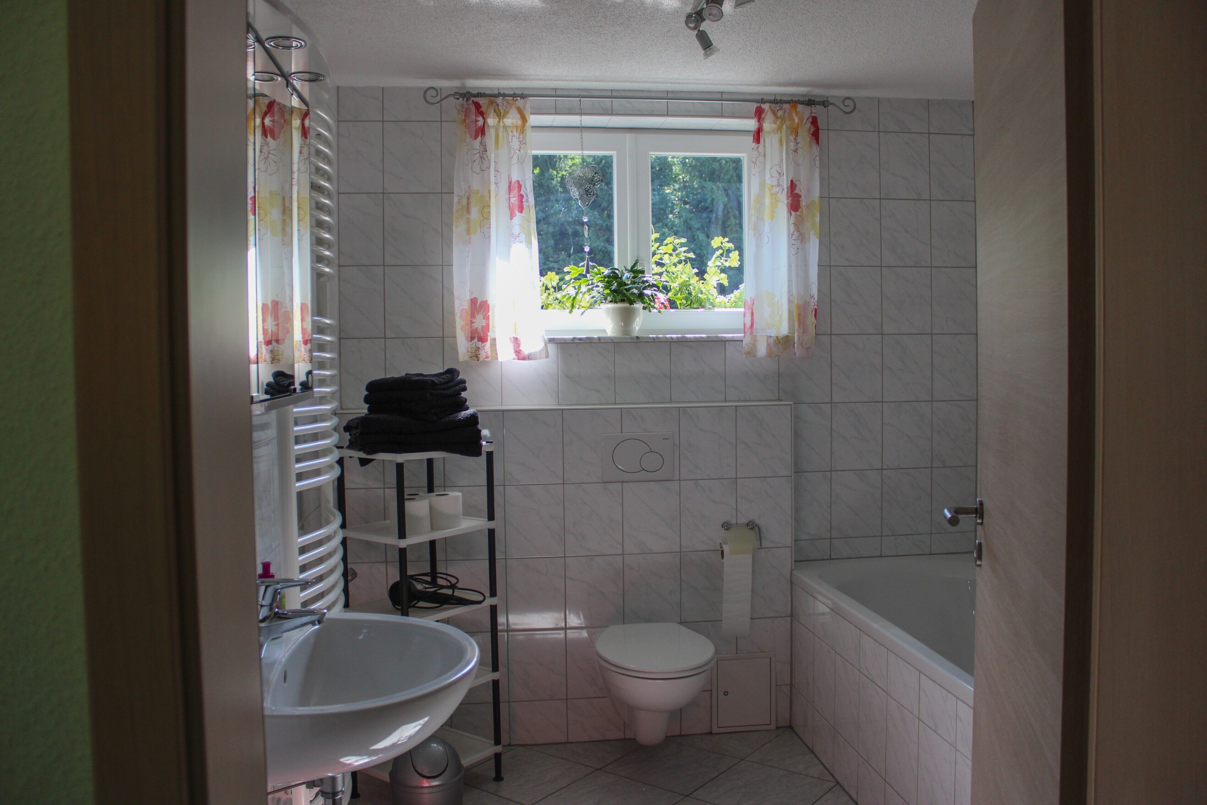 A bathroom with a toilet, sink, and bathtub.