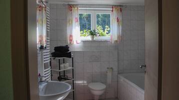 A bathroom with a toilet, sink, and bathtub.