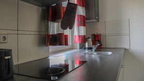 Une cuisine dotée d’un plan de travail en acier inoxydable, d’une bouilloire et d’un grille-pain.