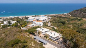 Ein Küstenwohngebiet mit modernen Häusern, einer Straße und einem Strand im Hintergrund.
