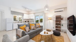 Ein modernes Wohnzimmer mit einem grauen Sofa, einem Couchtisch und einem gemusterten Teppich.
