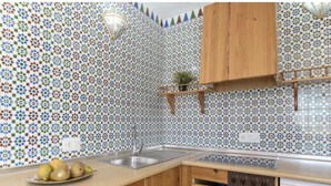 A kitchen with patterned tile backsplash, wooden cabinets, a sink, and a dishwasher. - Conil Group Getaway With Pool (Conil de la Frontera)