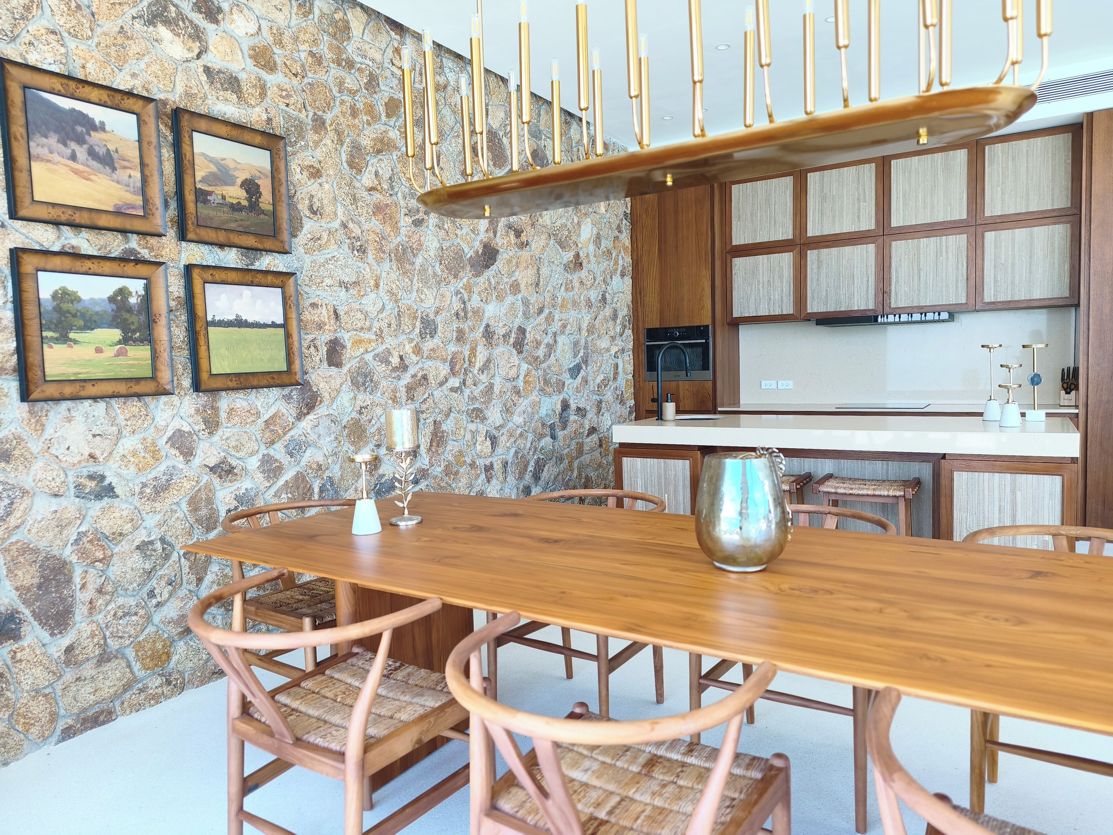 Un espace repas avec un mur en pierre, une table en bois et des chaises.