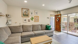 Un salon avec un canapé, une table basse et une porte donnant sur un balcon.