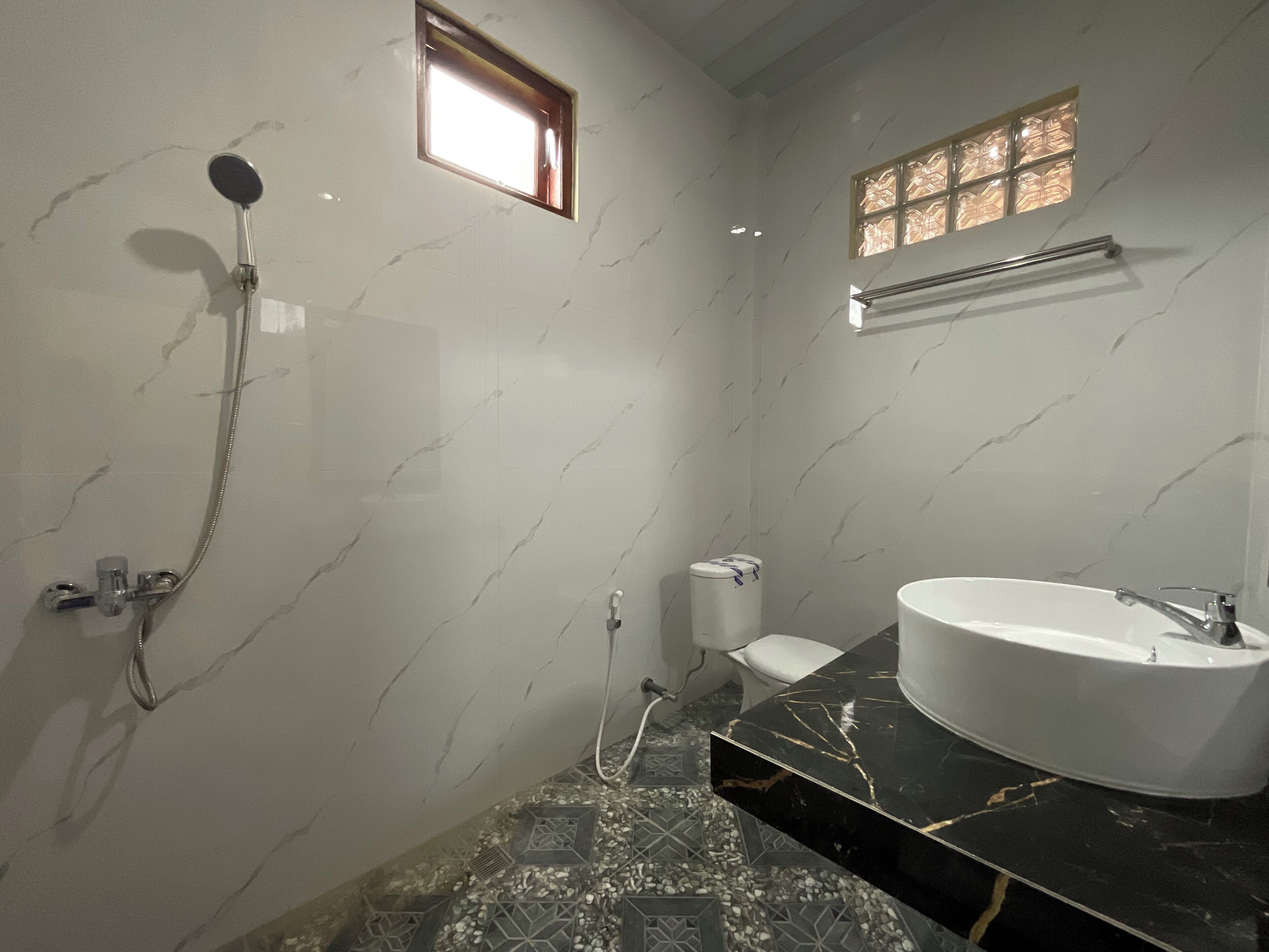 A bathroom with a freestanding bathtub, a showerhead, and a toilet.