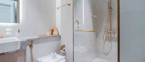 Ein modernes Badezimmer mit Toilette, Waschbecken und Duschbereich.