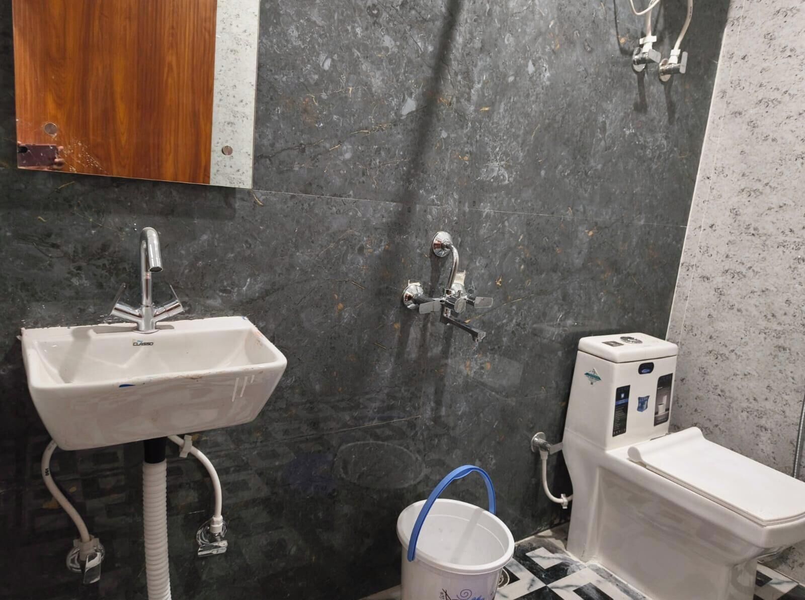 Une salle de bain avec un lavabo blanc, des toilettes et une douche.