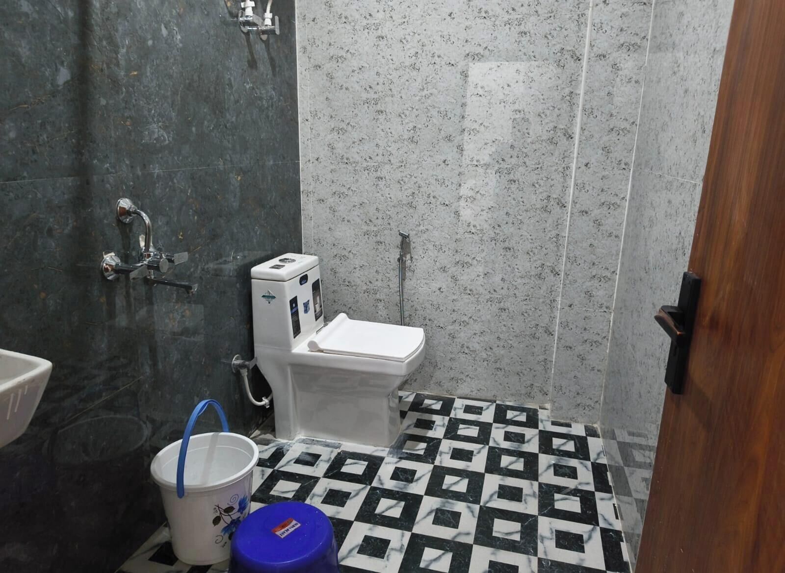 A bathroom with a toilet, a shower, and a sink.