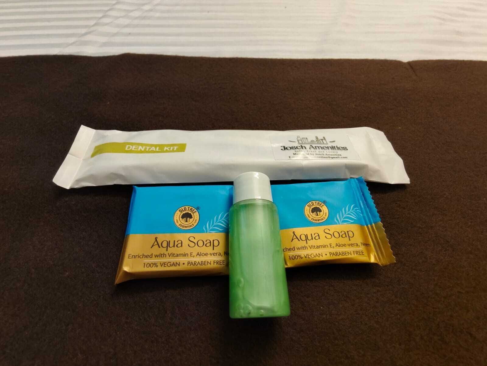 A dental kit and two bars of Aqua Soap on a brown surface.