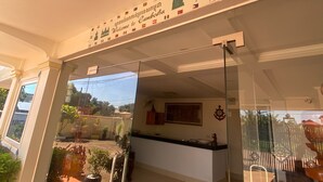 Zona de recepción con puerta de vidrio, un cartel que dice "Bienvenido a Camboya" y vistas al exterior.