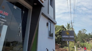 A modern building with the sign "ARNA INN" indicating a hotel. - Arna Inn Luxury Stay (Bhatkal)