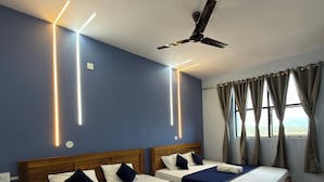 A hotel room with two beds, wooden headboards, and a ceiling fan. - Arna Inn Luxury Stay (Bhatkal)