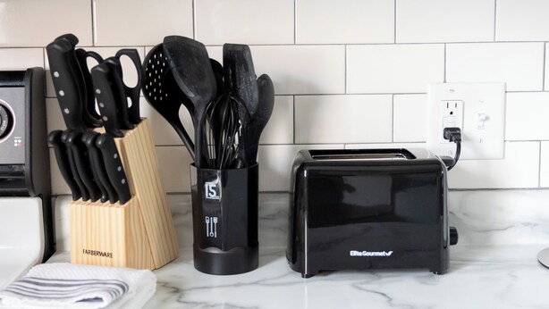 A kitchen with a marble countertop, a knife block, a spice rack, and a toaster. - Near K-State Campus - Central Manhattan Stay (Manhattan)