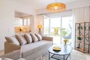 A modern living room with a sofa, a coffee table, and a bookshelf. - Island Hills- Sunshine, Apartment (Rhodes)