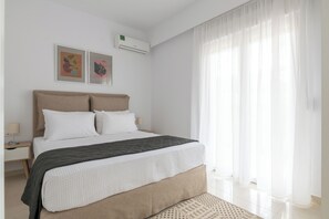 Quarto moderno com cama, mesa de cabeceira e ar condicionado.