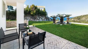 Una terrazza con mobili da esterno e vista su una collina e il mare.