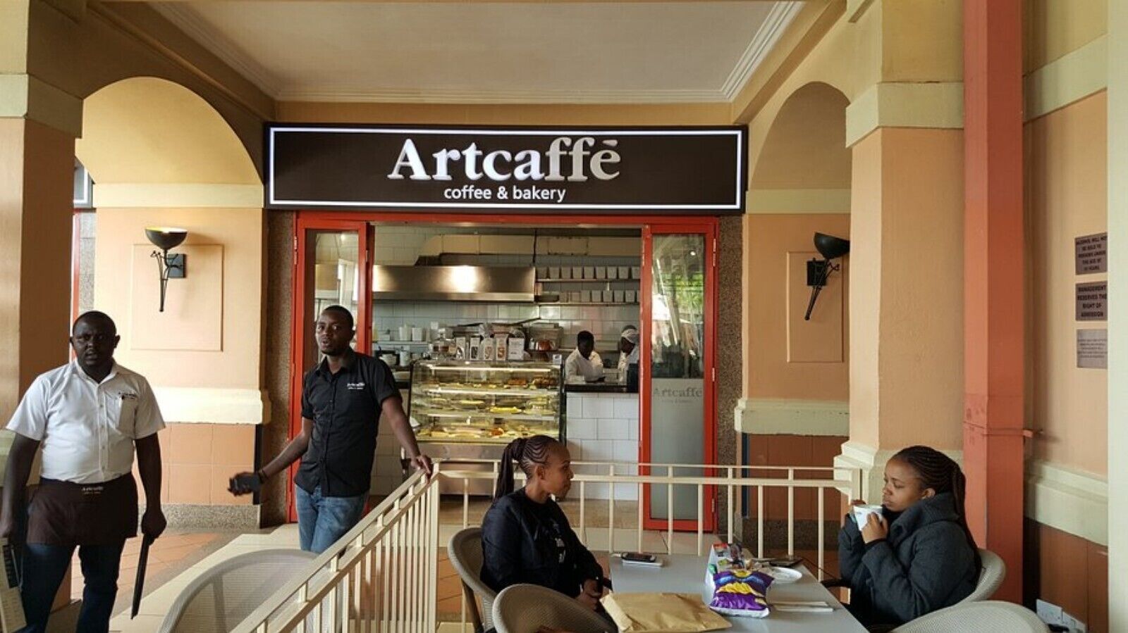 An indoor cafe with a sign reading "Artcaffe coffee & bakery".
