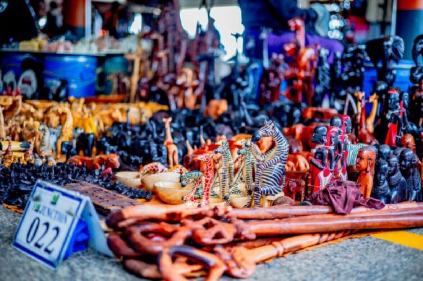 Ein Marktstand mit verschiedenen Waren, darunter Figuren, Schmuck und Textilien.