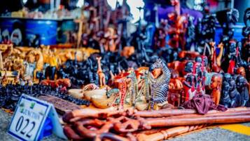Ein Marktstand mit verschiedenen Waren, darunter Figuren, Schmuck und Textilien.