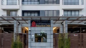 Un edificio moderno con un cartello che riporta la scritta "RIRAONE" e un ingresso recintato.