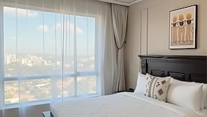Una camera da letto con un letto grande, vista sulla città e una lampada a soffitto moderna.