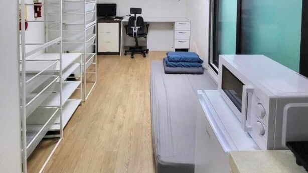 Une salle de consultation équipée d’un lit, d’un bureau avec un ordinateur et d’une étagère.