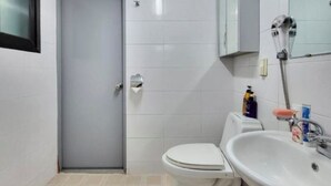 Une petite salle de bain moderne, équipée de toilettes, d’un lavabo et d’un miroir.