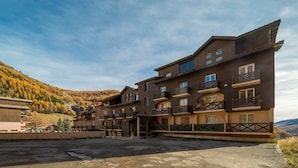 Un hotel a più piani con balconi, con una catena montuosa sullo sfondo.