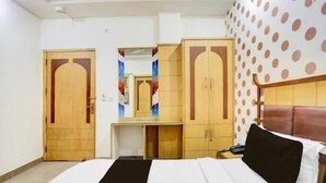 A hotel room with a bed, a desk, a wardrobe, and a polka dot wall. - LE ALFANSO BY AZAD RAM (New Delhi)