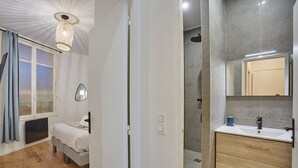 Une chambre à coucher moderne avec un lit, une table de chevet et une fenêtre avec des rideaux.