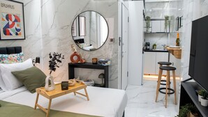 A modern bedroom with a bed, bedside table, and a mirror. - Koukaki Golden Lofts (Athens)