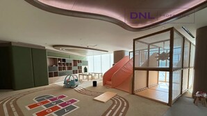Un interno moderno con un'area giochi, uno scivolo e un'ampia finestra.