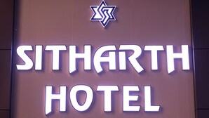 A sign for the SITHARTH HOTEL with a star symbol above the name. - Sitharth Hotel (Vikasnagar)