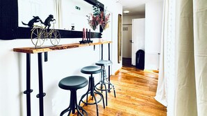 A modern kitchen with a wooden countertop, black stools, and a decorative bicycle. - Comfortable Room Near Kaufpark Alterlaa (Vienna)