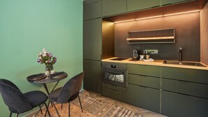 Eine kompakte Küche mit integriertem Backofen, Spüle und einer Holzausziehtafel.