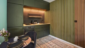 Eine moderne Küche mit dunklen Schränken, einem Einbauofen und einer Wand in Holzoptik.