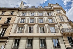 A multi-story building with a classic architectural style, featuring symmetrical windows and balconies. - Charming new flat in the centre of Paris (Paris)