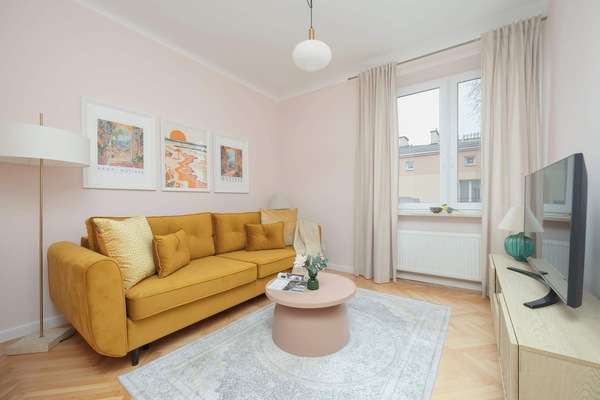 Bright and stylish living room with a mustard sofa and soft pastel décor, perfect for relaxing.