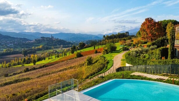 A pool with a view of a countryside landscape, including fields, trees, and distant hills. - Inviting apartment in Poppi with patio (Poppi)