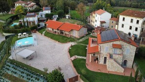 A residential area with stone buildings, a swimming pool, and solar panels. - Spacious apartment with infinity pool (Poppi)