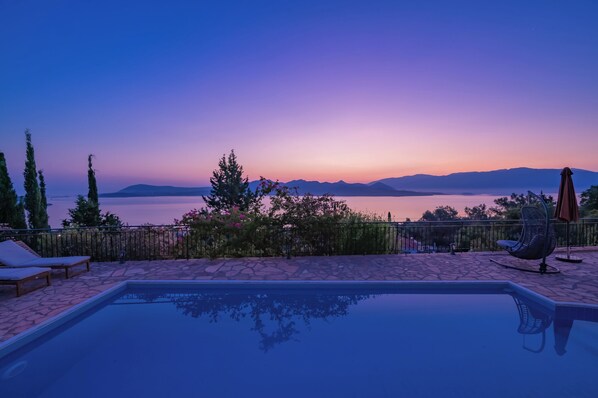 Ein Pool mit Blick auf Berge und einen Sonnenuntergang.