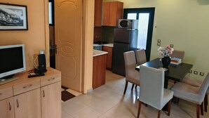 Cozinha moderna com frigorífico, micro-ondas e fogão. Possui uma área de refeições com mesa e cadeiras.