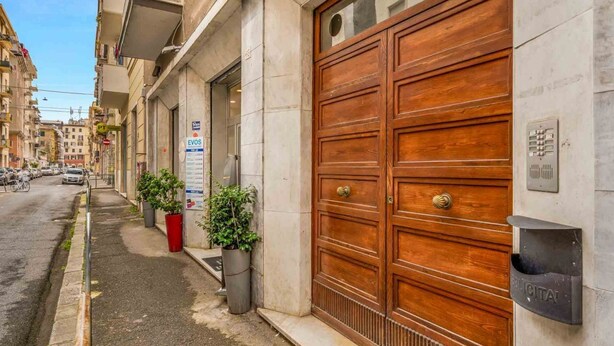 Un edificio con una amplia puerta doble de madera, un buzón y un cartel de EVOS.